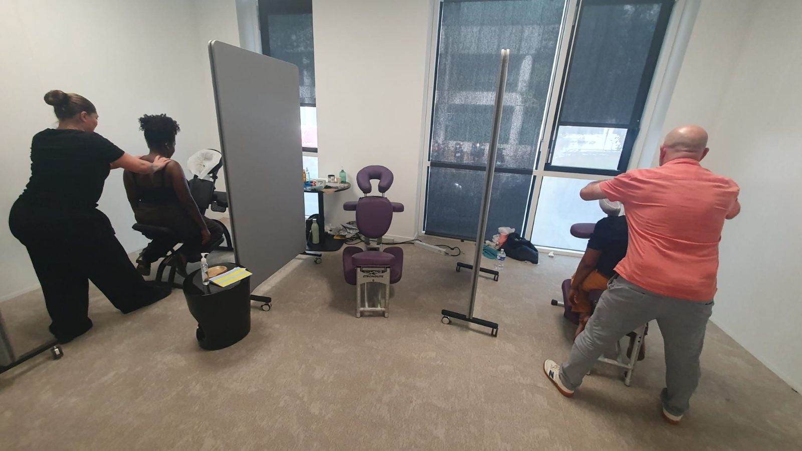 Deux praticiens massent des collaborateurs dans un open space